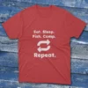 T-shirt in red featuring "Eat, Sleep, Fish, Camp" and the word "Repeat" with circular arrows on a light blue background.