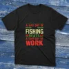 Black T-shirt with bold colorful text saying "A bad day of fishing beats a good day of work," shown on a light blue wooden background.