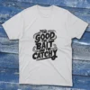 A white T-shirt with the phrase "The Good, The Bait, And The Catchy" in bold text, shown on a light blue background.