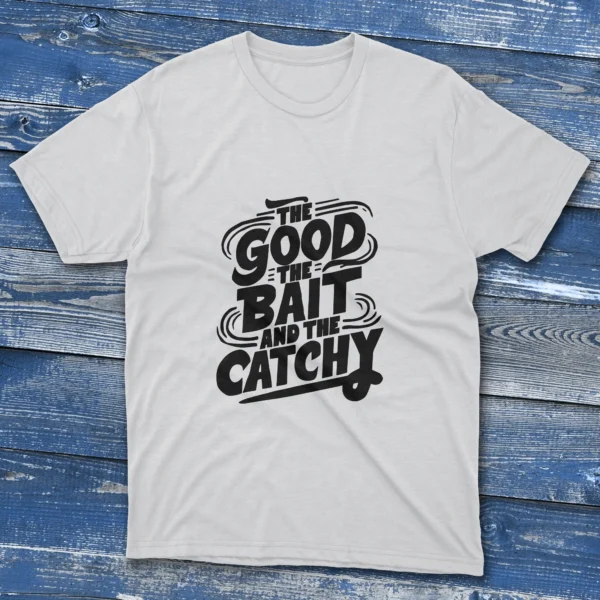 A white T-shirt with the phrase "The Good, The Bait, And The Catchy" in bold text, shown on a light blue background.